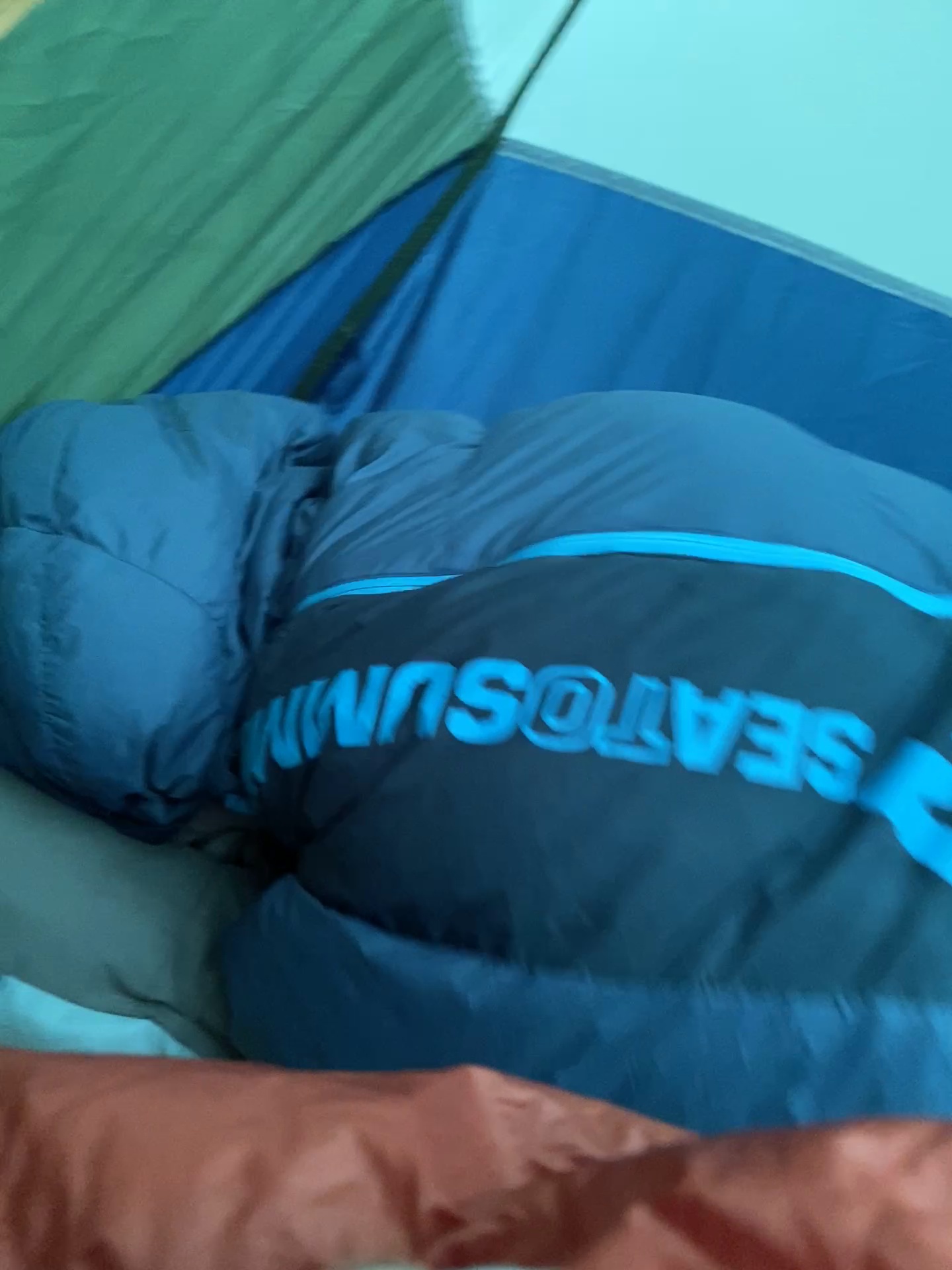 Backpacking sleep system with sleeping bag and pad packed for an overnight trip